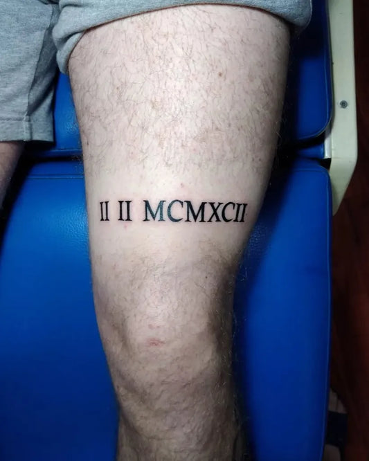 Small Blackwork Roman Numerals Tattoo on Men Leg by @tattoostarstudiojagodina