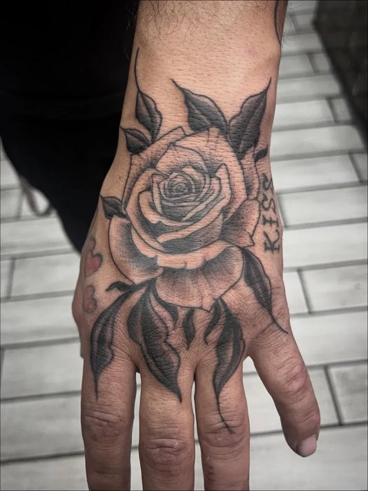 Small Blackwork Rose Leaves Heart on Men Hand Tattoo by @seangallaghertattoos