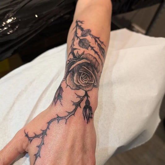 Small Blackwork Rose Thorns on Women Wrist Tattoo by @ben.lerouge