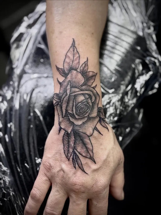 Small Blackwork Rose and Leaves on Women Wrist Tattoo by @_artistrybylex