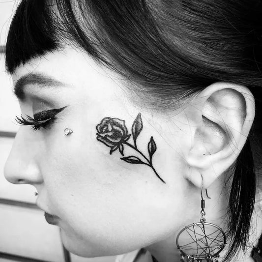 Small Blackwork Rose on Women Face Tattoo by @ericworx