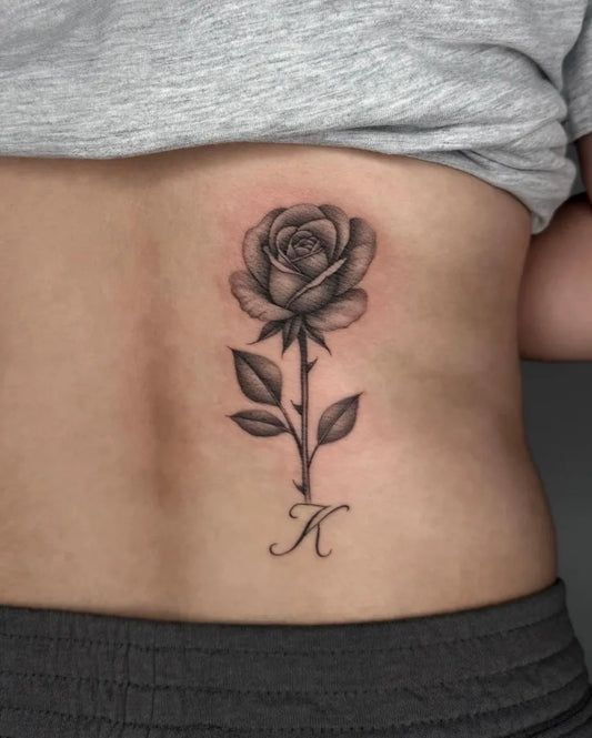 Small Blackwork Rose with K on Women Back Tattoo by @mygodjose