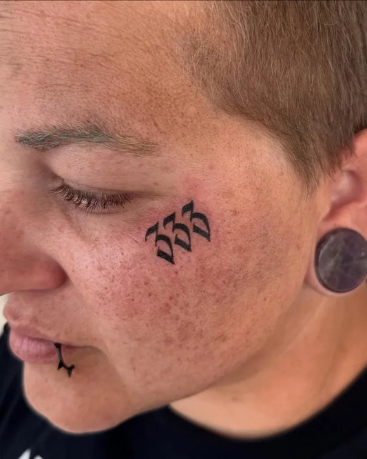 Small Blackwork Runes on Women Face Tattoo by @honeyb_fineart