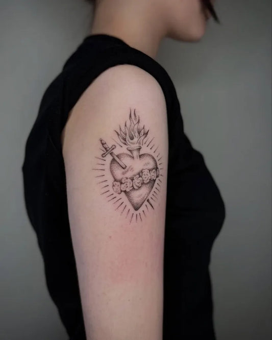 Small Blackwork Sacred Heart with Flames and Sword Tattoo on Women Upper Arm by @nicnpoke