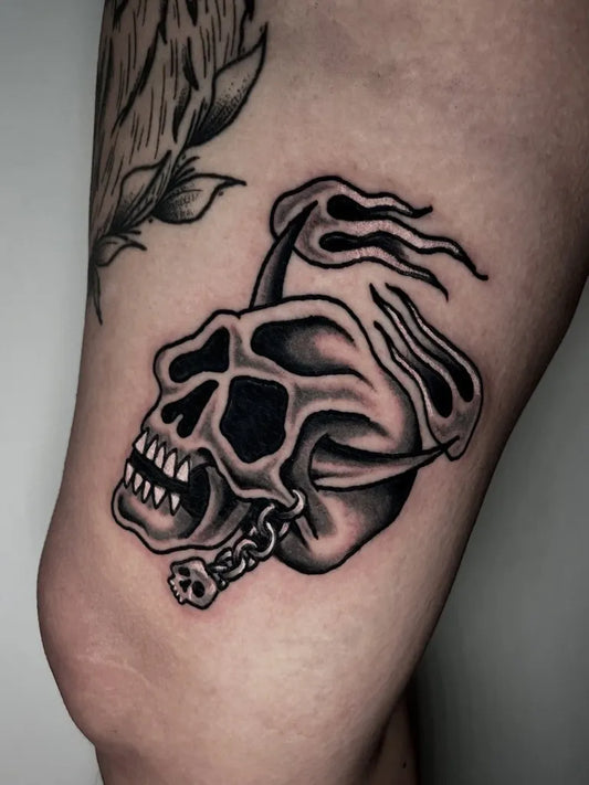 Small Blackwork Skull with Flames and Chain on Women Arm Tattoo by @normally.cool