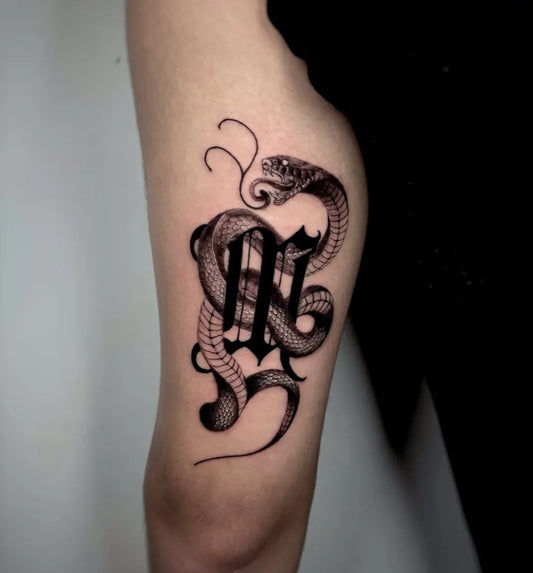 Small Blackwork Snake and Letters on Women Upper Arm Tattoo by @black_fafa_tattoo