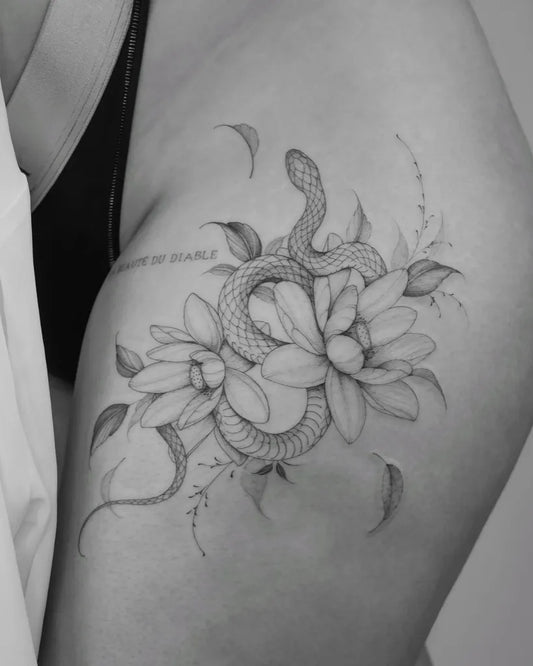 Small Blackwork Snake and Lily on Women Thigh Tattoo by @la.source.tattoo