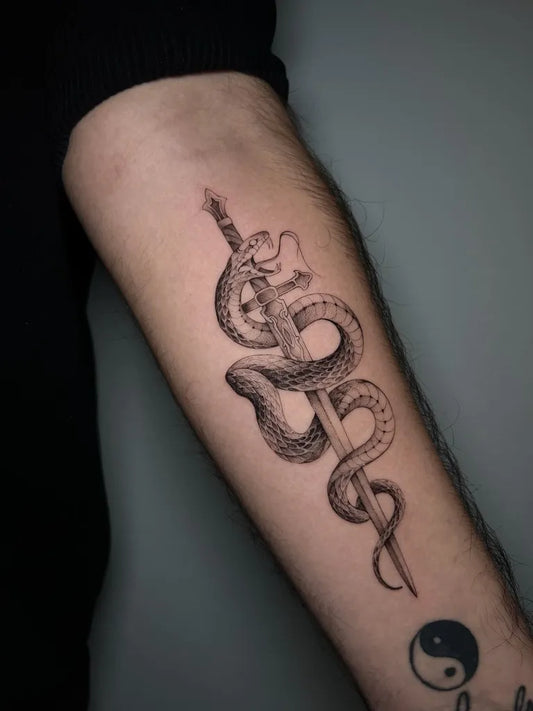Small Blackwork Snake and Sword on Men Arm Tattoo by @emma.pm.tattoo
