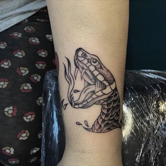 Small Blackwork Snake with Flames on Women Arm Tattoo by @reca_tattoo