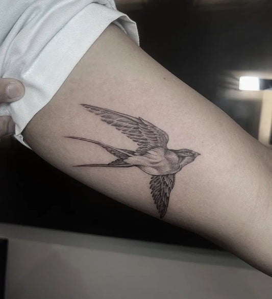 Small Blackwork Sparrow Tattoo on Women Arm by @thebossink.tattoo