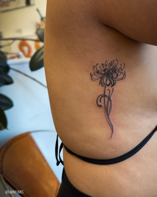 Small Blackwork Spider Lily Tattoo on Women Rib by @lanny.inks