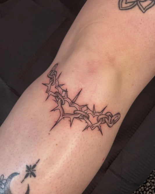 Small Blackwork Spiked Chain and Hearts Tattoo on Women Knee by @lucybethantattoos