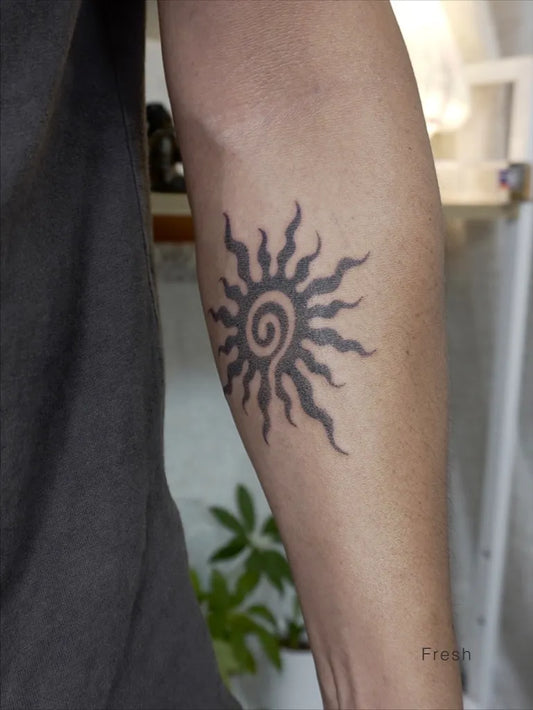 Small Blackwork Spiral Sun on Men Arm Tattoo by @namaste_poke