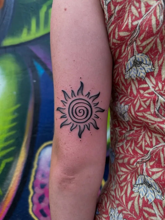 Small Blackwork Spiral Sun on Women Arm Tattoo by @dariogarciateruel