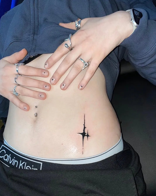 Small Blackwork Star Tattoo on Women Stomach by @armin.agne