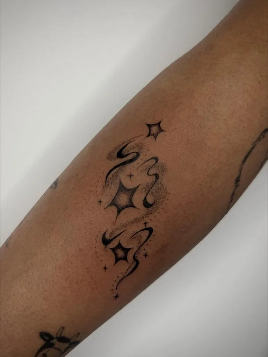 Small Blackwork Stars and Swirls Tattoo on Women Arm by @p0melow