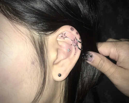 Small Blackwork Stars and Vines Tattoo on Women Behind the Ear by @keeshetattoo