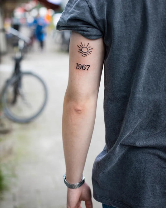 Small Blackwork Sun 1967 Tattoo on Men Arm by @annedekkertattoo