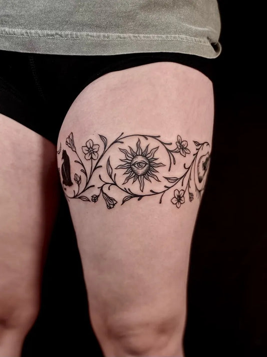 Small Blackwork Sun and Flowers on Women Thigh Tattoo by @witchneytattoos