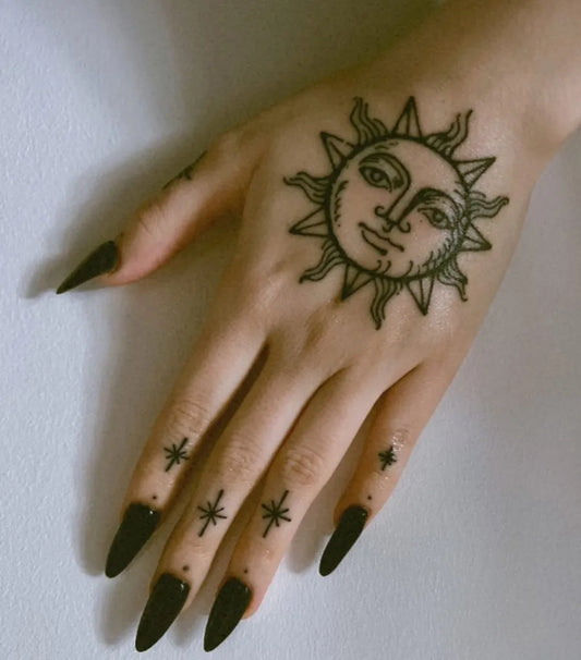 Small Blackwork Sun with Stars on Women Hand Tattoo by @sophalxndra_