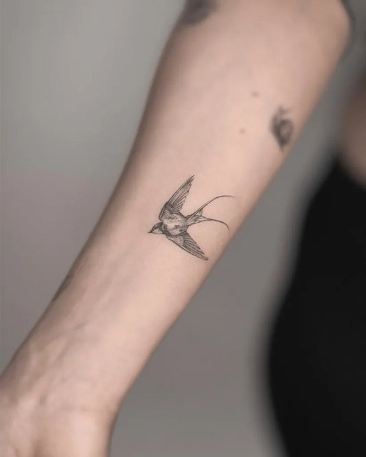 Small Blackwork Swallow Tattoo on Women Arm by @eden_tattoos