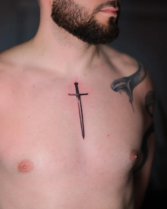 Small Blackwork Sword on Men Chest Tattoo by @arenambar