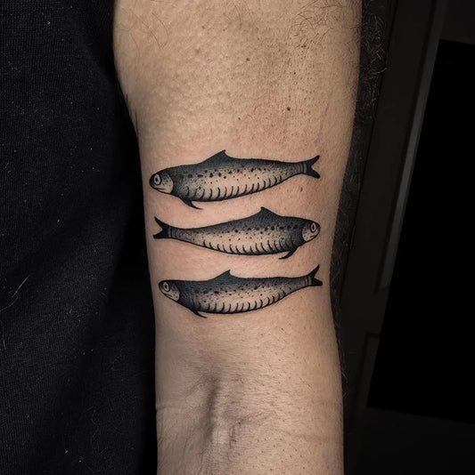 Small Blackwork Three Fish Tattoo on Men Arm by @n.michon.tattoo
