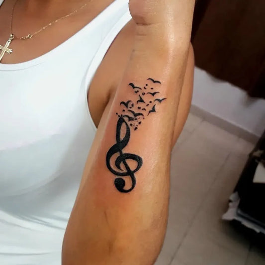 Small Blackwork Treble Clef and Birds Music Tattoo on Women Arm by @inkbybruno