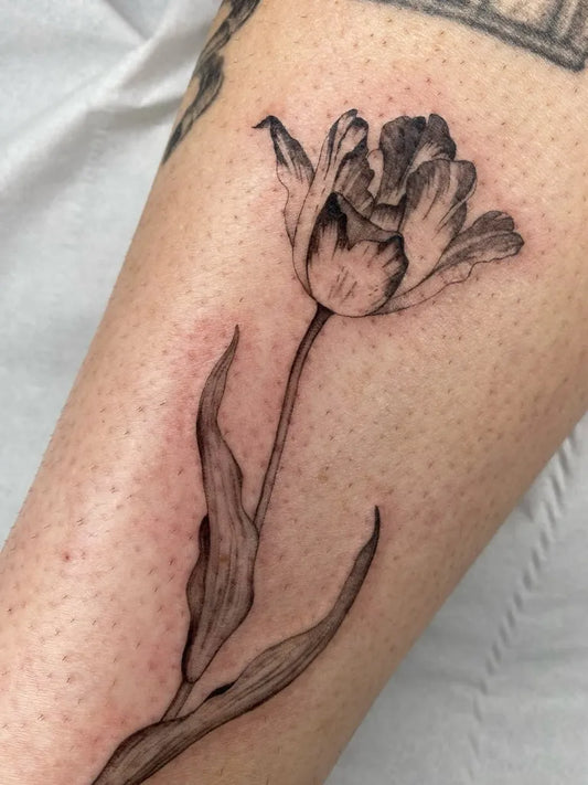 Small Blackwork Tulip Tattoo on Women Arm by @heloisegeslain