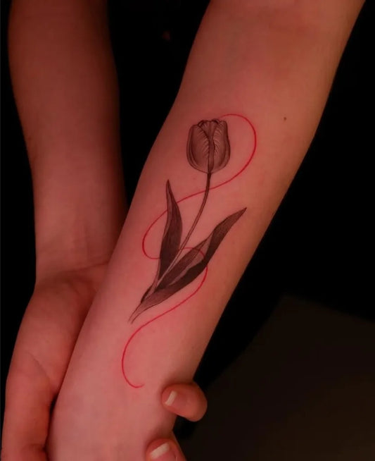 Small Blackwork Tulip and Red Swirl Tattoo on Women Arm by @exp.haus