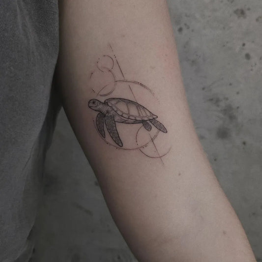 Small Blackwork Turtle with circles Tattoo on Women Arm by @dobby.tattoo