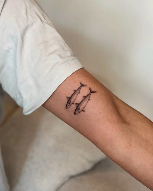 Small Blackwork Two Fish Tattoo on Men Forearm by @mayink.nl