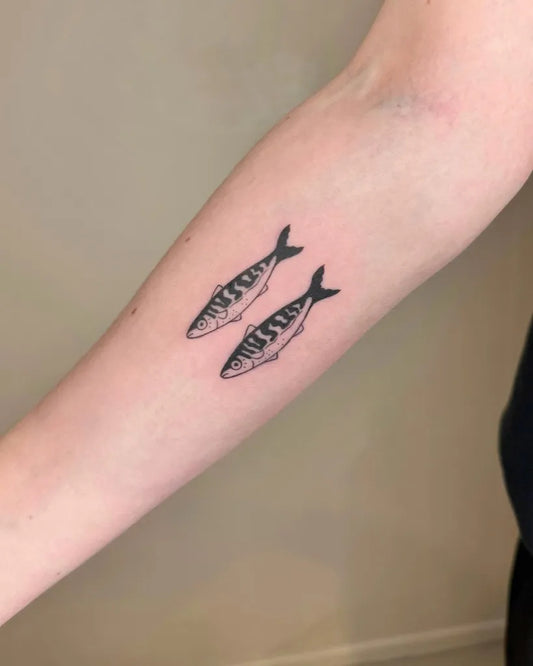 Small Blackwork Two Striped Fish Tattoo on Women Forearm by @raissa.ink
