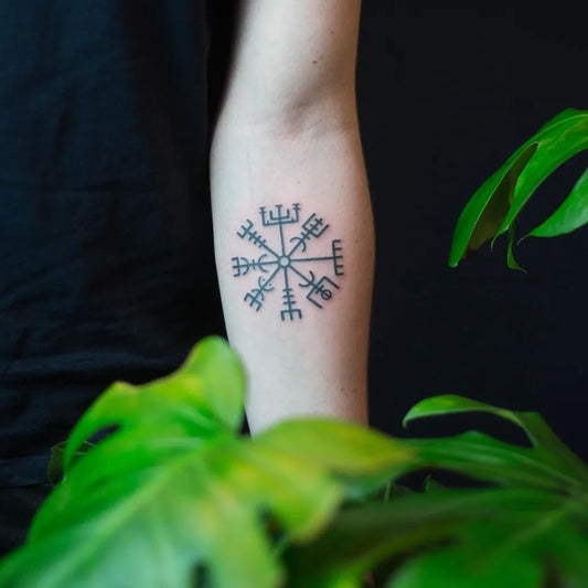 Small Blackwork Vegvisir Tattoo on Women Arm by @grube.linie