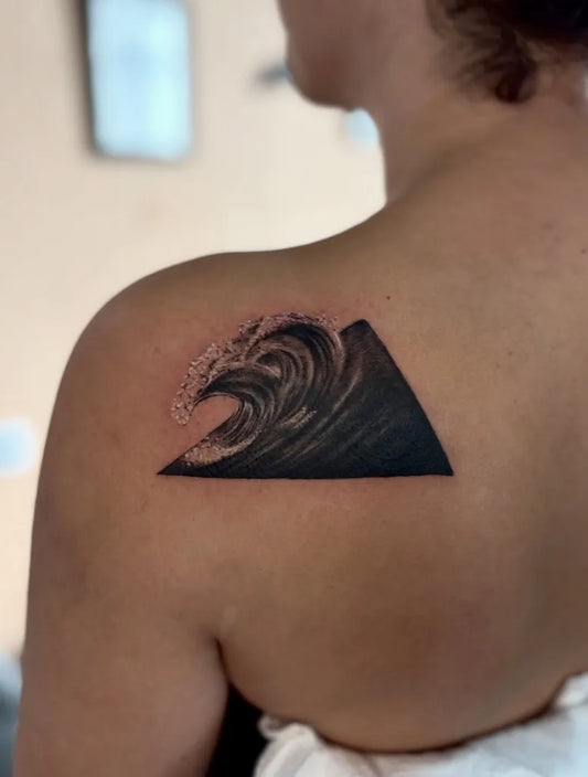 Small Blackwork Wave Triangle Tattoo on Women Shoulder by @roomcraft.tattoo