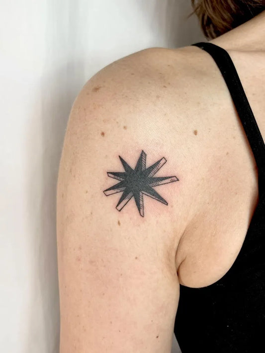 Small Blackwork Woodcut Star Tattoo on Women Shoulder by @pelc.tt