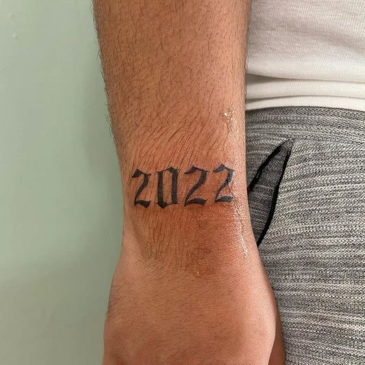 Small Blackwork Year Number Tattoo on Men Forearm by @inkedby.chlo