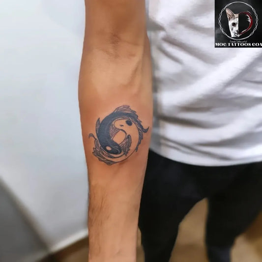 Small Blackwork Yin Yang Koi Tattoo on Men Arm by @mog_tattoos_goa