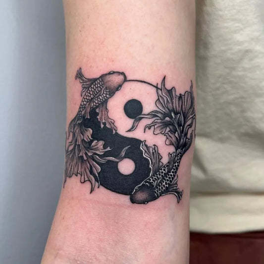 Small Blackwork Yin Yang Koi Tattoo on Women Arm by @mandmtattooing