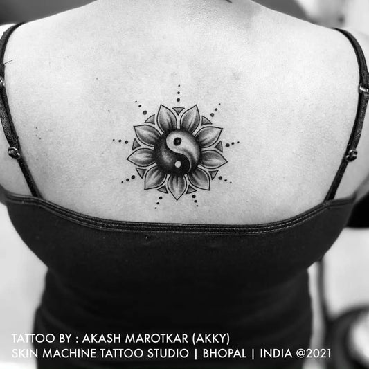 Small Blackwork Yin Yang Sunflower Tattoo on Women Back by @akash_marotkar