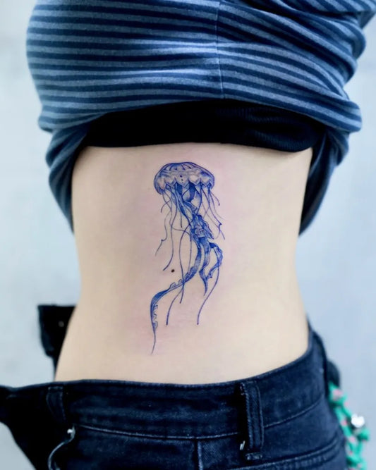 Small Blue Jellyfish Tattoo on Women Back by @tattooist_taker