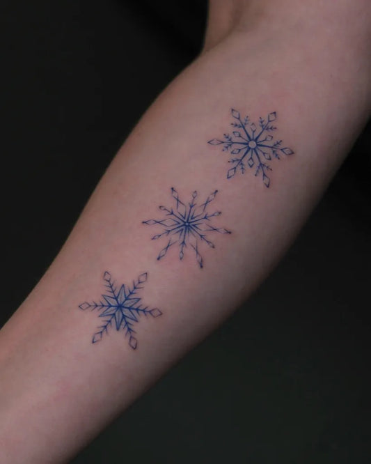 Small Blue Three Snowflakes Tattoo on Women Arm by @han.z_tattoo