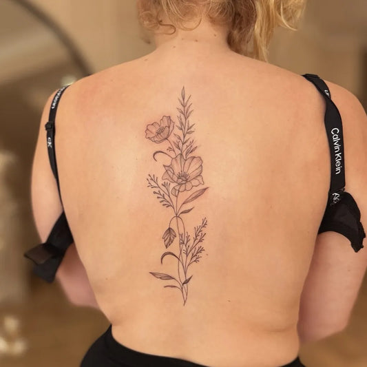 Small Botanical Poppy and Branches on Women Spine Tattoo by @ellierose.tattoos