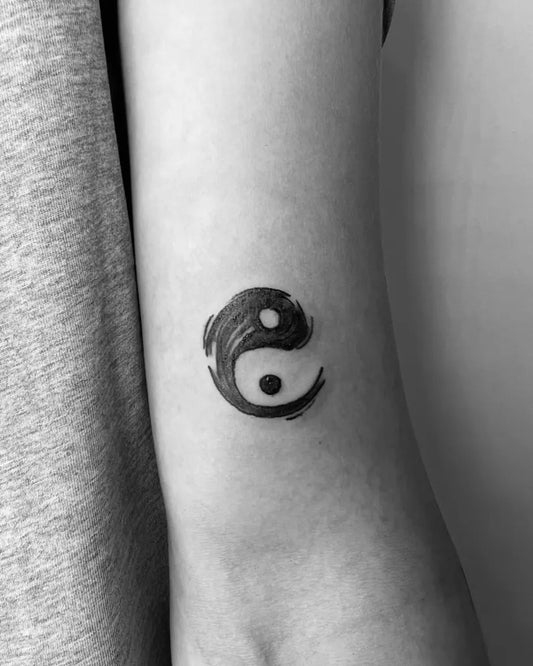 Small Brush Stroke Yin Yang Tattoo on Women Arm by @airestattoo_olb