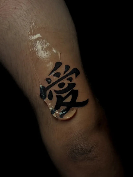 Small Chinese Love Character Tattoo on Men Forearm by @talientoo.ink