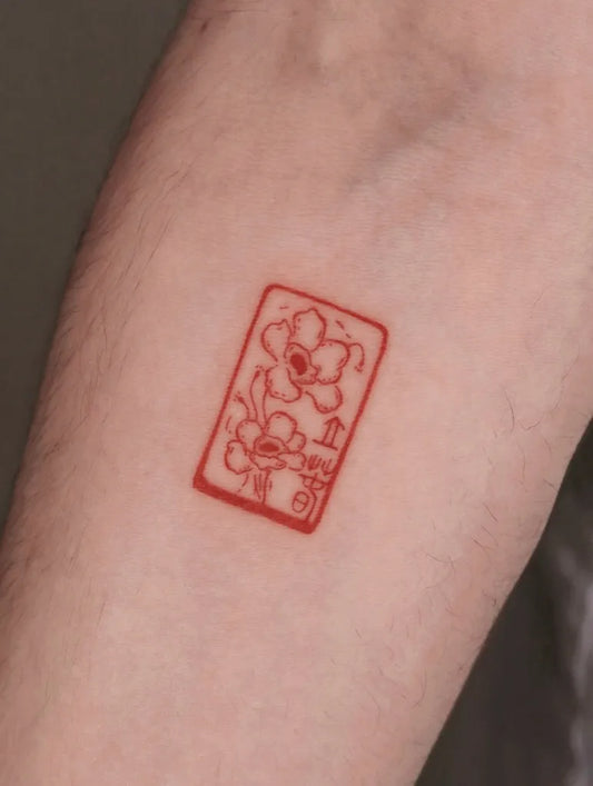 Small Chinese Red Flower Seal Tattoo on Women Arm by @idont_i