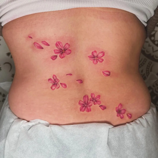 Small Color Realism Cherry Blossom Petals on Women Back Tattoo by @nileursag