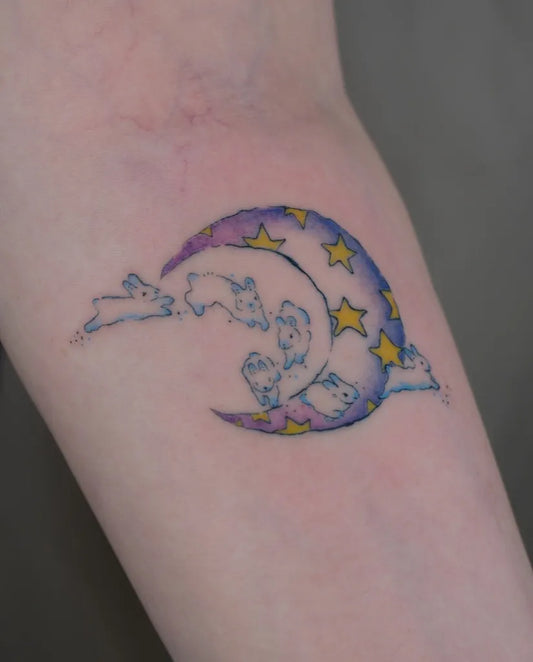 Small Colorful Crescent Moon and Bunnies Tattoo on Women Arm by @zeys.tatu