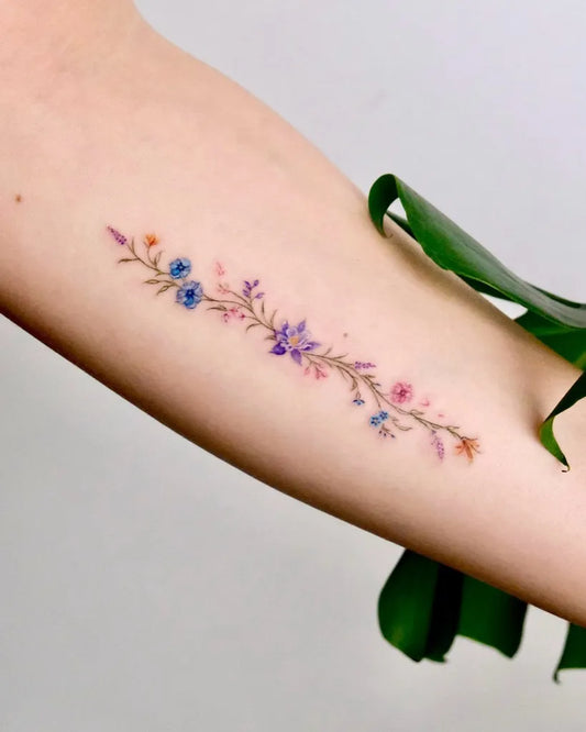 Small Colorful Flowers Tattoo on Women Arm by @aysenurbiingol