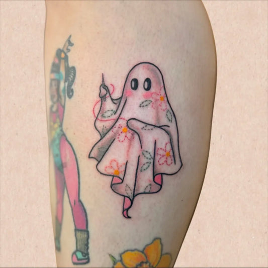 Small Colorful Ghost with Flowers Tattoo on Women Thigh by @mstraditionaltattoo